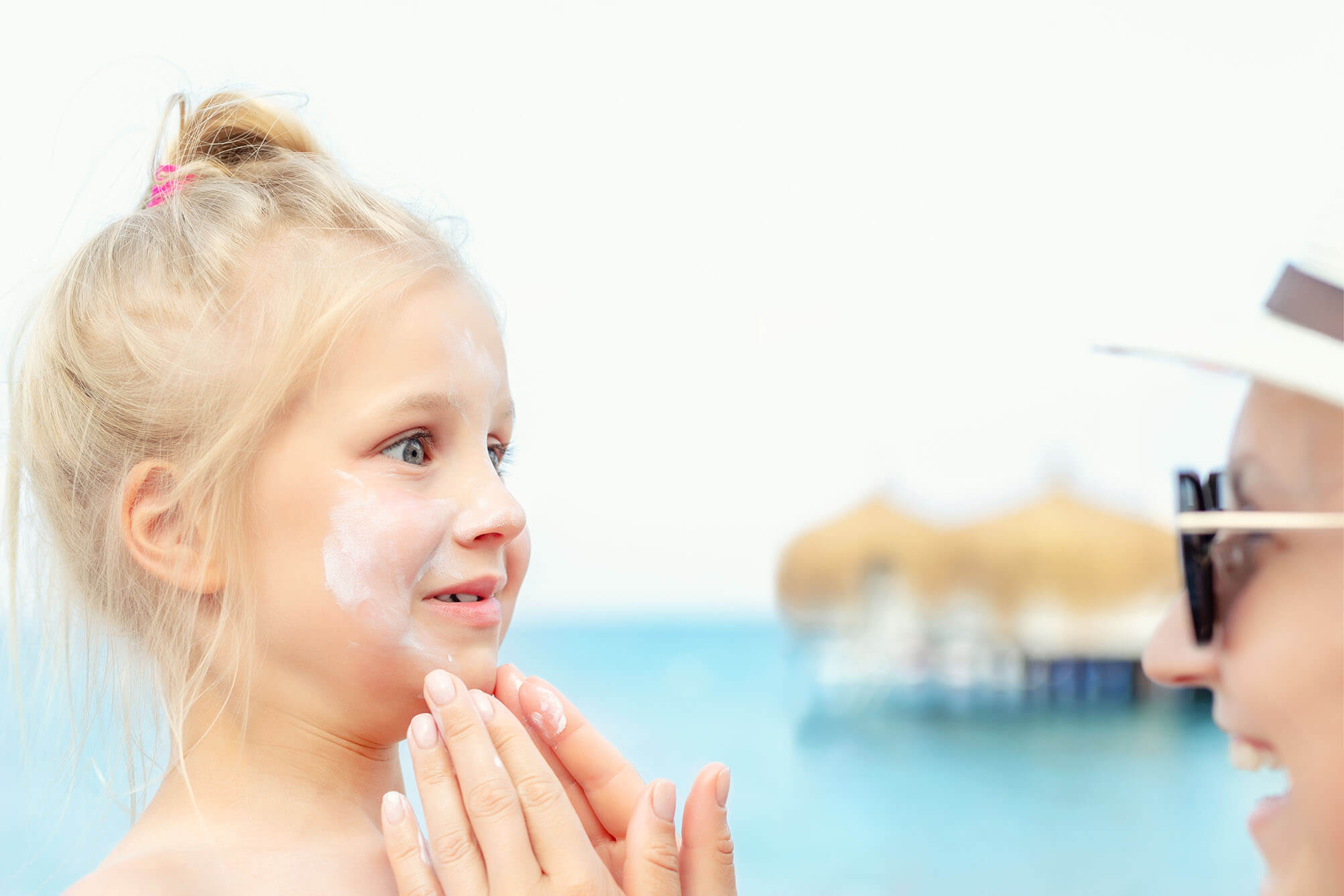 Mother Applying Sunscreen Protection Creme On Cute Little Toddle